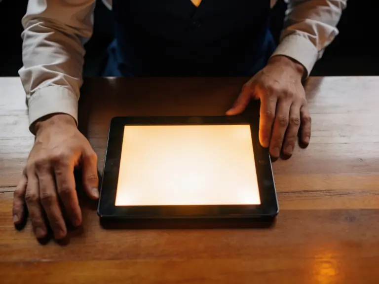 A pair of hands resting on a tablet